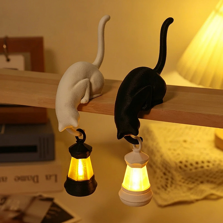 Black and white hanging cat lantern ornaments displayed on a wooden shelf